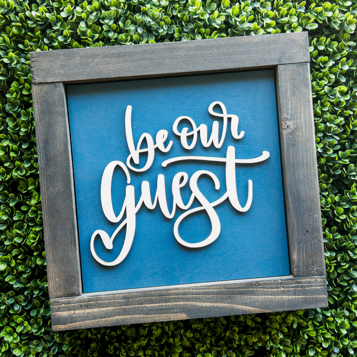 Interchangeable porch decor tile with Be Our Guest white script on blue in a grey frame | Millie & Co.