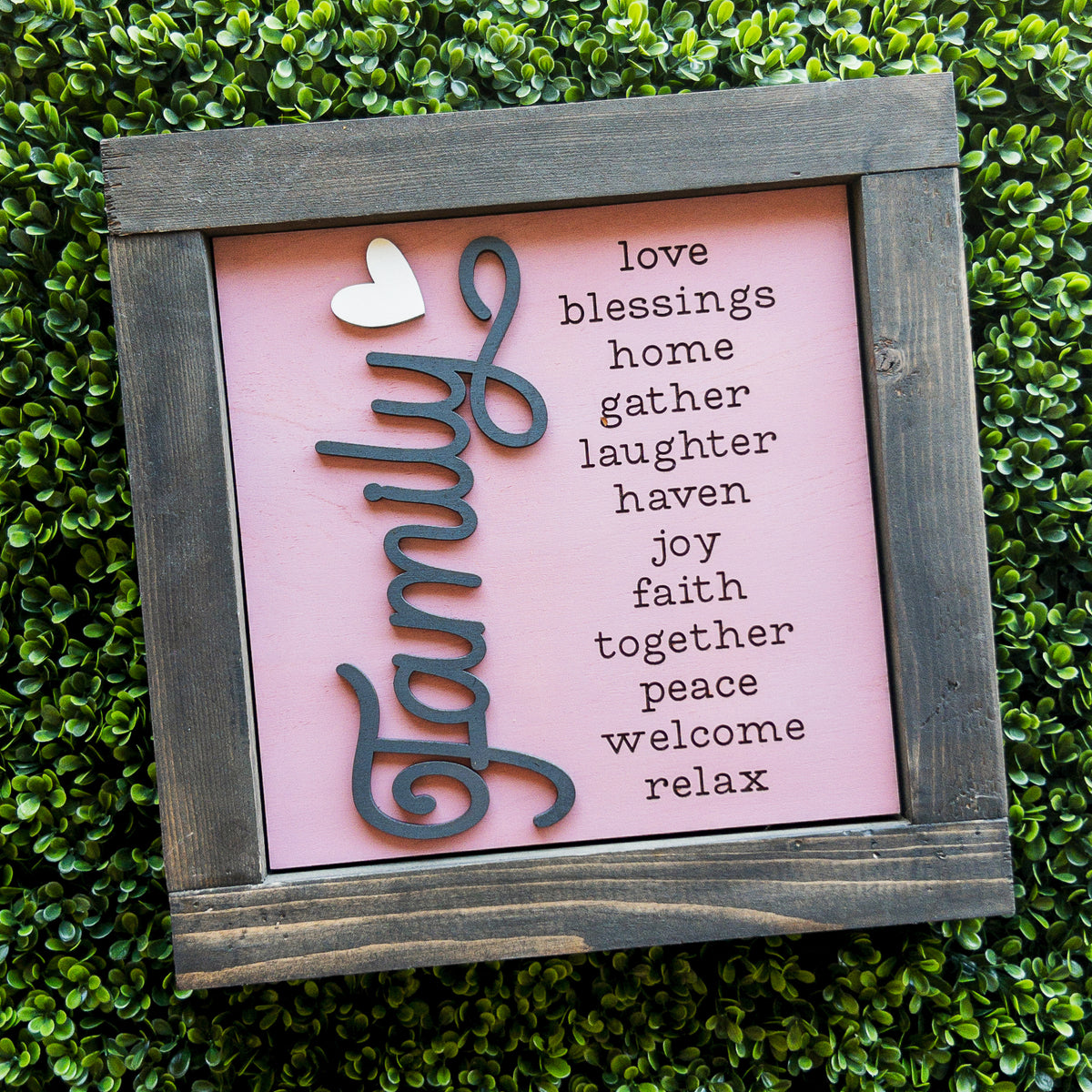 Interchangeable porch decor tile with raised Family script and a word list on pink in a grey frame | Millie & Co.