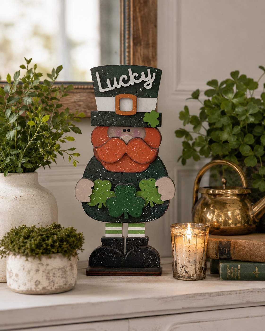 Hand-painted Lucky Leprechaun stander with shamrock hat and beard displayed on a mantel between potted greenery and a candle