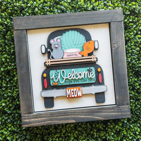 Cat lover porch decor tile of a black truck with a teal Welcome sign and a Meow license plate | Millie & Co.