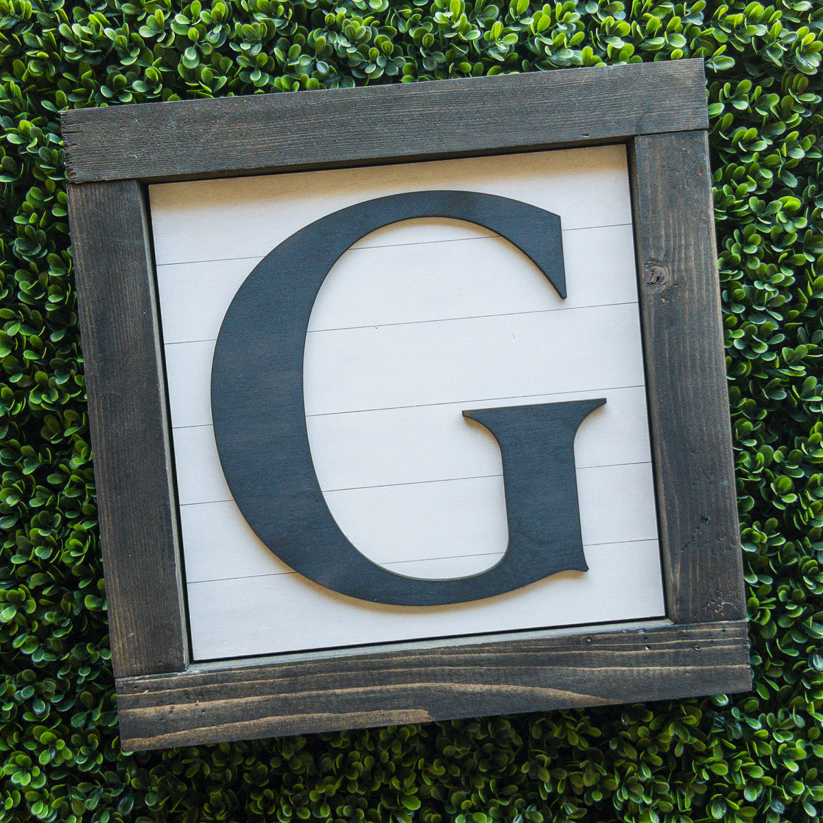 Personalized initial porch decor tile with a large letter on white shiplap in a grey frame | Millie & Co.