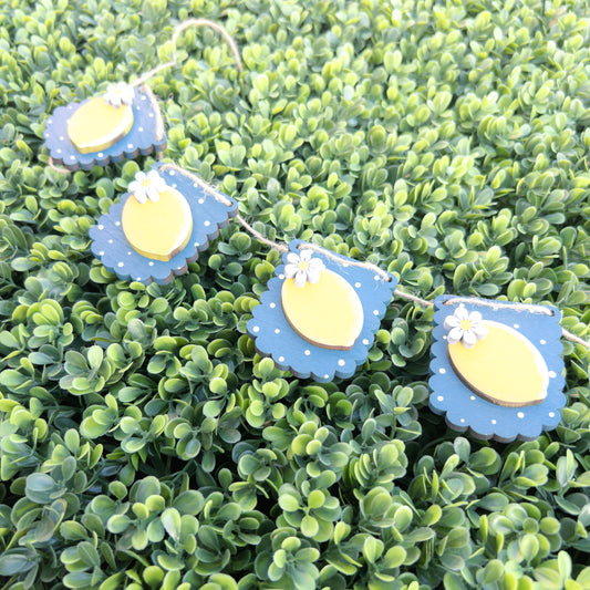 Lemon porch decor ladder wrap with four navy scalloped tags, yellow lemons, and white daisies on jute twine, Millie & Co.