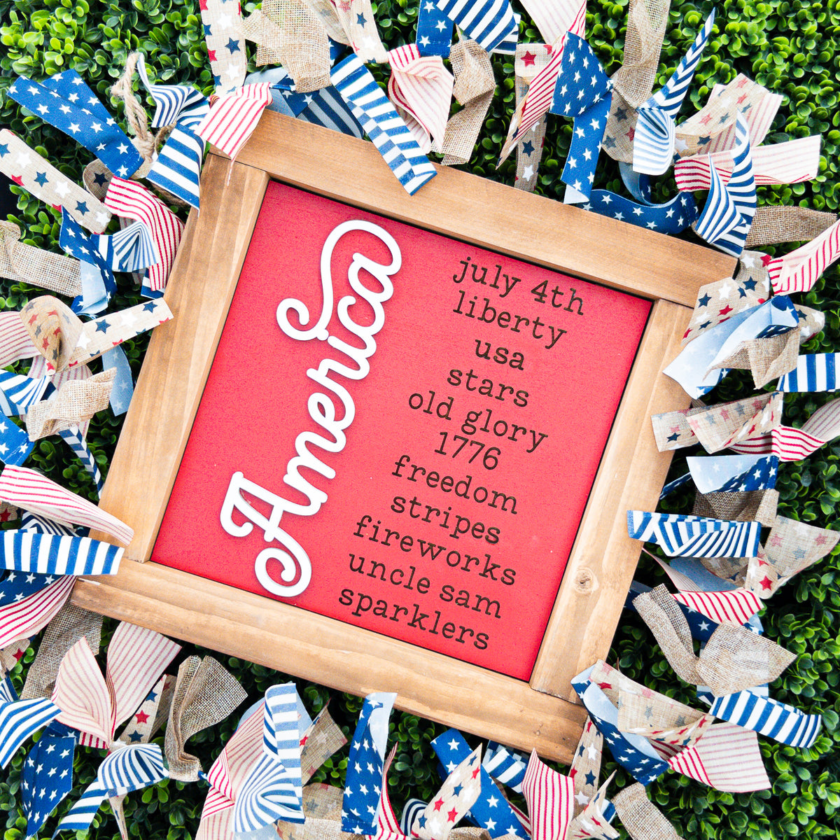 Patriotic porch decor tile in red with a raised white America script and a list of patriotic favorites, Millie & Co.