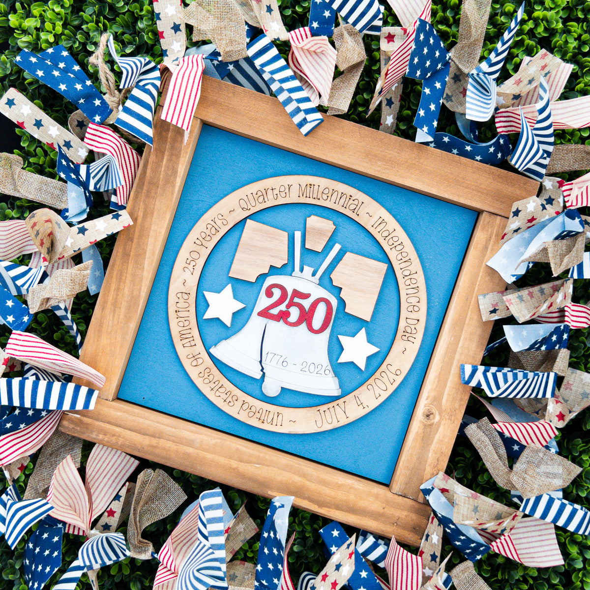 Patriotic porch decor tile with a white Liberty Bell wearing a red 250 on steel blue with an engraved wood ring, Millie & Co.