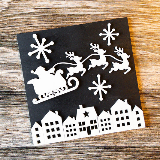 black and white silhouette interchangeable Christmas tile of Santa's sleigh over a village - Millie & Co.