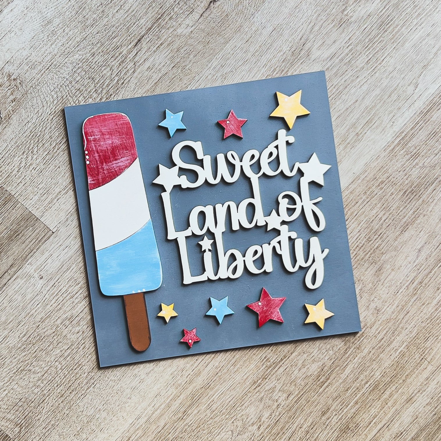Patriotic porch decor tile of a red, white, and blue bomb pop popsicle — Millie & Co.