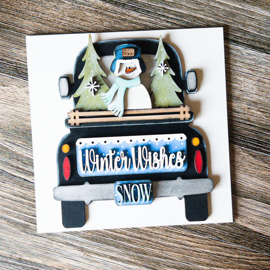 hand-painted interchangeable winter tile featuring a truck with trees and a snowman - Millie & Co.
